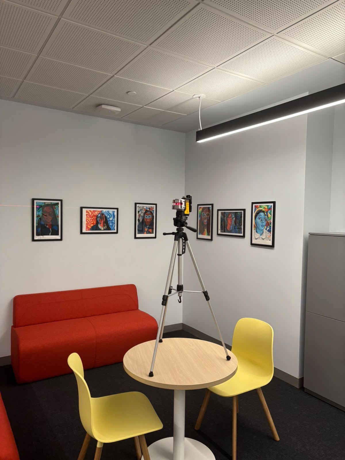 Colorful framed student portraits installed in a lounge